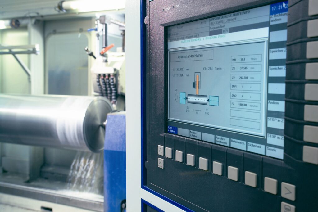 Moderne CNC-Rundschleifmaschine im Einsatz beim Außenrundschleifen eines Hydraulikzylinders aus dem Werkstoff C45